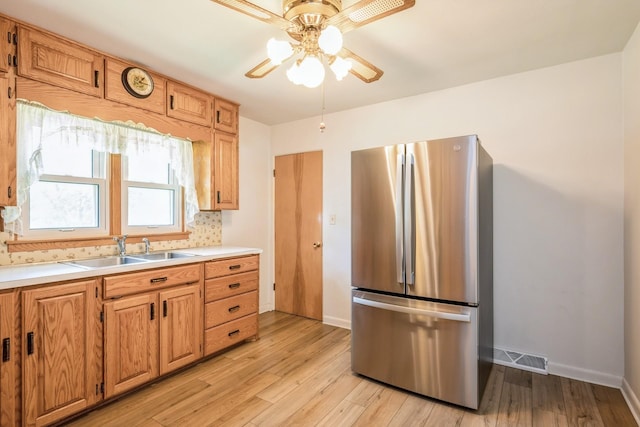 4326 E Washburn Rd, Waterloo, IA 50702 - kitchen with freestanding refrigerator, ceiling fan, light wood-type flooring, and light countertops