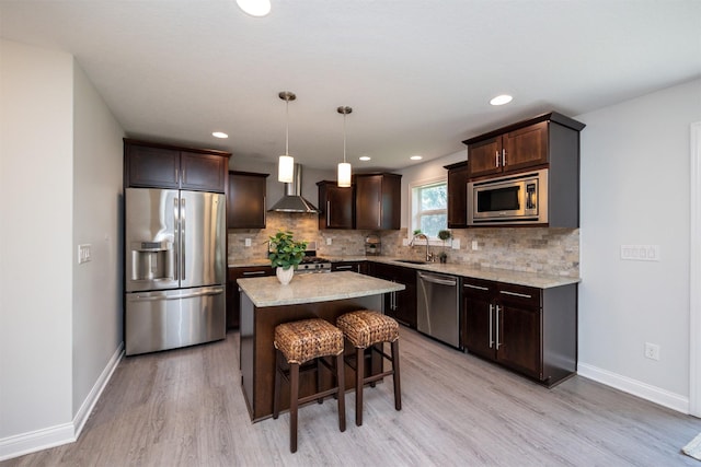 296 S 82nd St, West Des Moines, IA 50266 - kitchen featuring stainless steel appliances, wall chimney range hood, dark brown cabinets, light wood-type flooring, and decorative backsplash