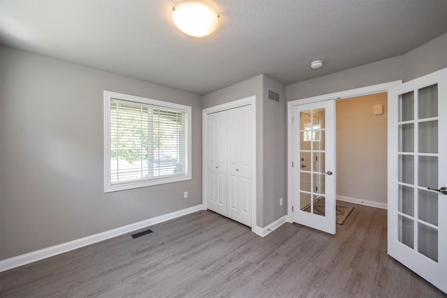 296 S 82nd St, West Des Moines, IA 50266 - unfurnished bedroom featuring french doors, wood finished floors, and a closet
