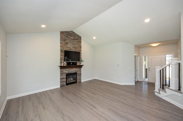 296 S 82nd St, West Des Moines, IA 50266 - unfurnished living room featuring wood finished floors, a fireplace, vaulted ceiling, stairs, and recessed lighting