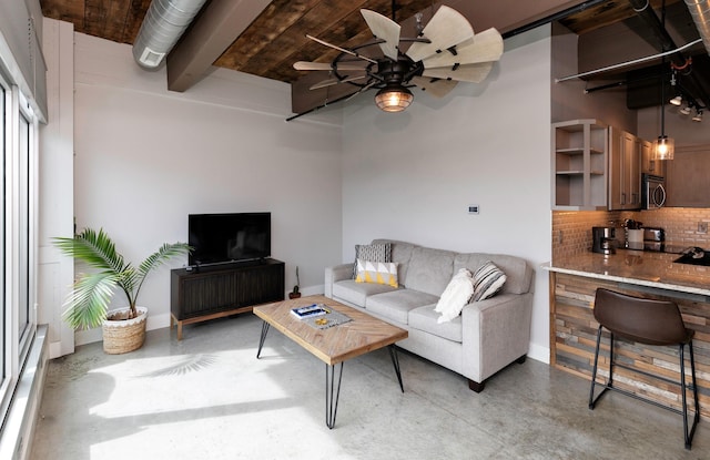 120 SW 5th St Unit 306, Des Moines, IA 50309 - living area with finished concrete flooring, ceiling fan, and beamed ceiling