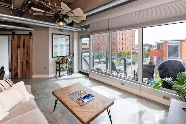 120 SW 5th St Unit 306, Des Moines, IA 50309 - living area with finished concrete floors, a barn door, a ceiling fan, and a view of city