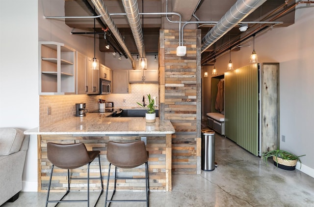 120 SW 5th St Unit 306, Des Moines, IA 50309 - kitchen with stainless steel microwave, concrete floors, backsplash, and open shelves