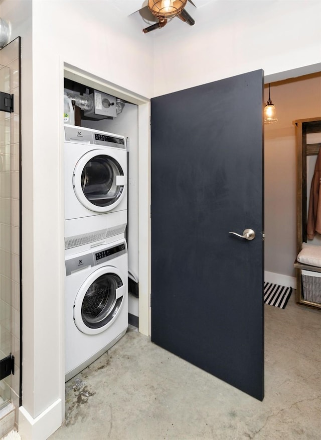 120 SW 5th St Unit 306, Des Moines, IA 50309 - washroom with stacked washer / dryer and a ceiling fan