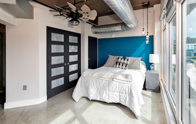 120 SW 5th St Unit 306, Des Moines, IA 50309 - bedroom featuring finished concrete flooring, multiple windows, and french doors