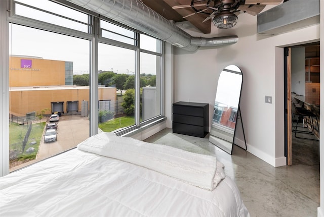 120 SW 5th St Unit 306, Des Moines, IA 50309 - bedroom featuring baseboards and concrete floors