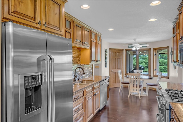904 Pleasant St SE, Bondurant, IA 50035 - kitchen featuring appliances with stainless steel finishes, ceiling fan, light stone counters, recessed lighting, and brown cabinetry
