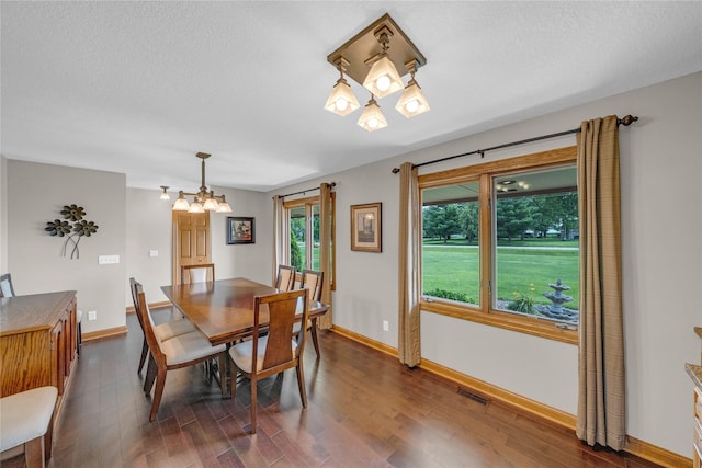 904 Pleasant St SE, Bondurant, IA 50035 - dining room with dark wood finished floors, a chandelier, and a textured ceiling
