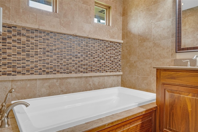 904 Pleasant St SE, Bondurant, IA 50035 - bathroom featuring vanity, a garden tub, and tile walls