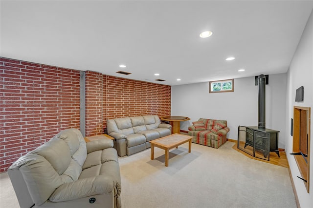 904 Pleasant St SE, Bondurant, IA 50035 - carpeted living room with a wood stove, recessed lighting, and brick wall