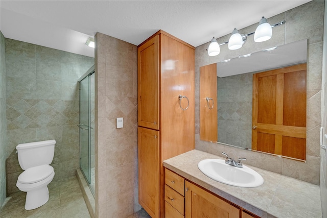 904 Pleasant St SE, Bondurant, IA 50035 - full bath featuring tile walls, vanity, a stall shower, and tile patterned flooring