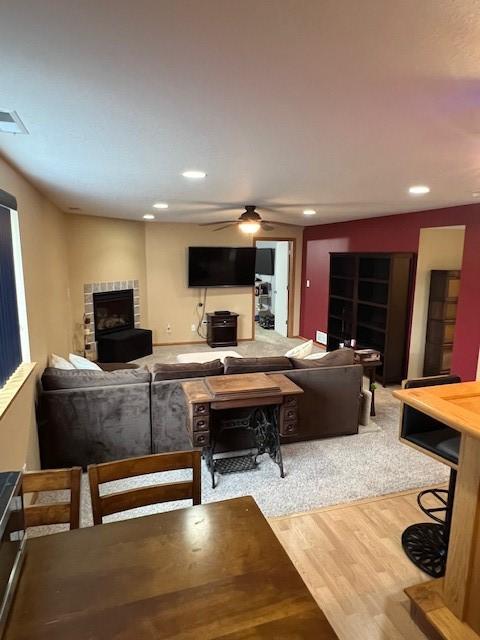 4806 Waller St, Ames, IA 50014 - living area featuring wood finished floors, a fireplace with raised hearth, recessed lighting, and a ceiling fan