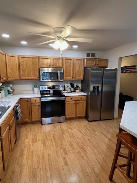 4806 Waller St, Ames, IA 50014 - kitchen with stainless steel appliances, ceiling fan, light wood-style floors, light countertops, and brown cabinets