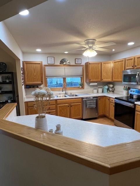 4806 Waller St, Ames, IA 50014 - kitchen with appliances with stainless steel finishes, light countertops, recessed lighting, ceiling fan, and brown cabinetry