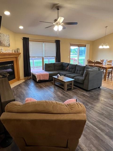 4806 Waller St, Ames, IA 50014 - living room with lofted ceiling, wood finished floors, a chandelier, a ceiling fan, and a glass covered fireplace