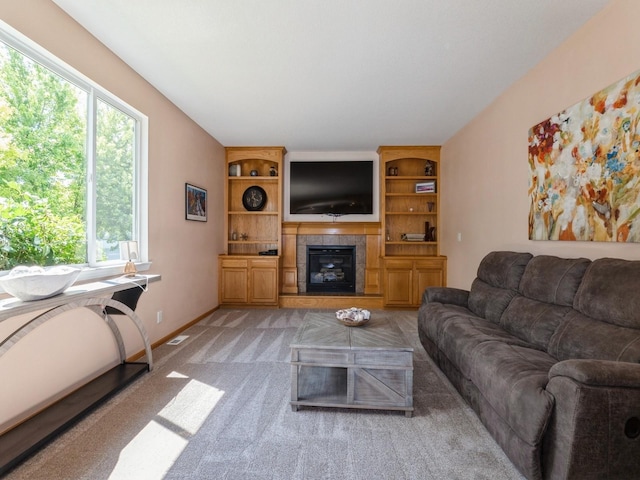 705 SE Whitetail Ln, Waukee, IA 50263 - living area with light carpet, a tiled fireplace, and built in shelves