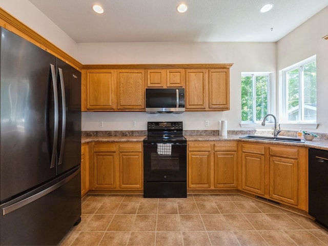 705 SE Whitetail Ln, Waukee, IA 50263 - kitchen with black appliances, brown cabinets, recessed lighting, and light tile patterned floors