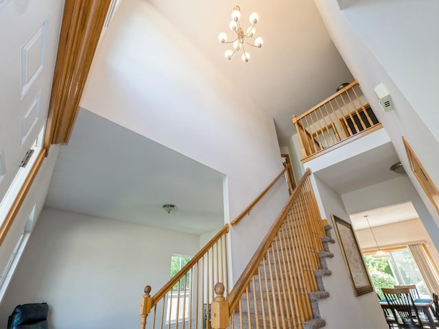 705 SE Whitetail Ln, Waukee, IA 50263 - stairs featuring a chandelier and a towering ceiling