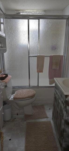 1924 4th St, Perry, IA 50220 - bathroom featuring vanity and bath / shower combo with glass door
