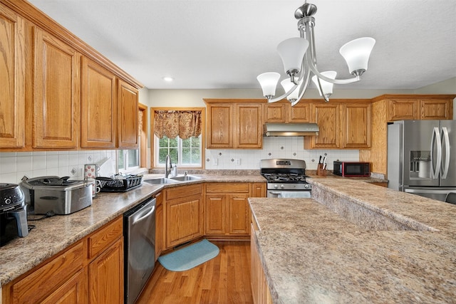 3413 Brook Run Dr, Des Moines, IA 50317 - kitchen featuring stainless steel appliances, under cabinet range hood, light wood-style floors, brown cabinets, and recessed lighting