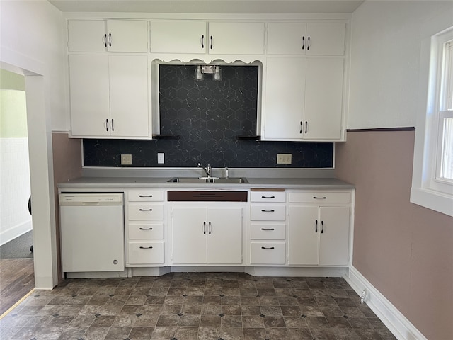117 W Broadway St, Colfax, IA 50054 - kitchen featuring dishwasher, backsplash, light countertops, and white cabinetry