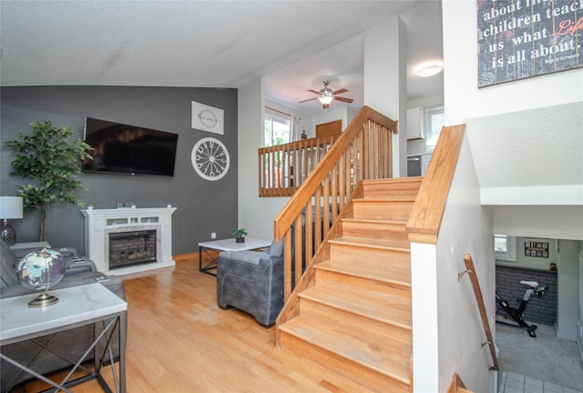 5420 SW 13th St, Des Moines, IA 50315 - stairway featuring a fireplace, a ceiling fan, lofted ceiling, and wood finished floors