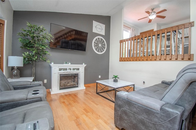 5420 SW 13th St, Des Moines, IA 50315 - living room with wood finished floors, vaulted ceiling, a ceiling fan, and a fireplace with raised hearth