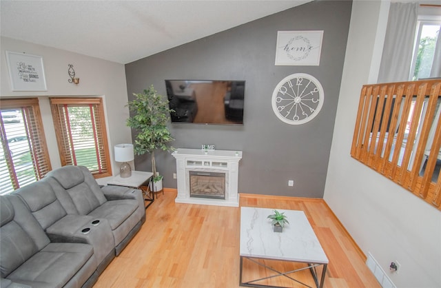 5420 SW 13th St, Des Moines, IA 50315 - living room featuring lofted ceiling, wood finished floors, healthy amount of natural light, and a high end fireplace