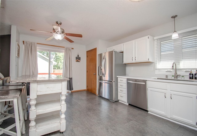 5420 SW 13th St, Des Moines, IA 50315 - kitchen featuring stainless steel appliances, white cabinetry, light countertops, a ceiling fan, and decorative light fixtures