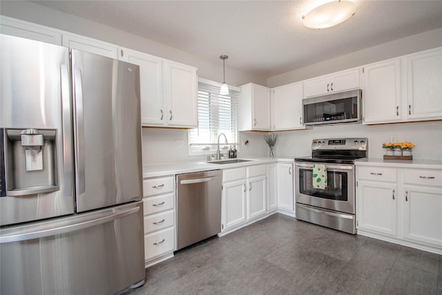 5420 SW 13th St, Des Moines, IA 50315 - kitchen featuring stainless steel appliances, white cabinets, light countertops, and pendant lighting