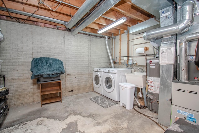 5420 SW 13th St, Des Moines, IA 50315 - unfinished below grade area featuring washing machine and dryer, water heater, and brick wall