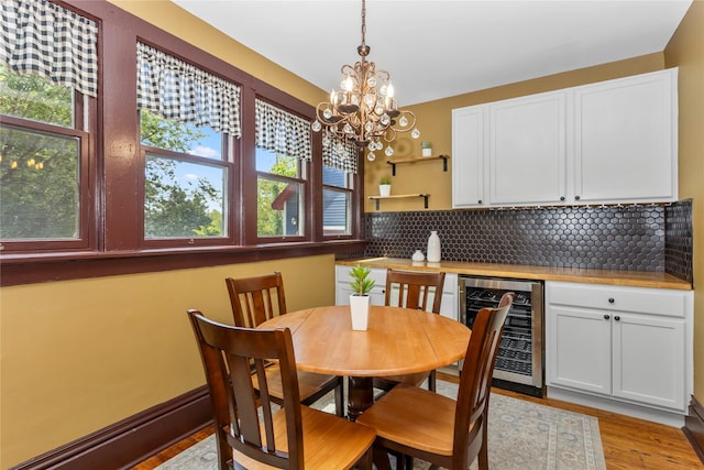 658 20th St, Des Moines, IA 50314 - dining area with wine cooler, a chandelier, and light wood-style flooring