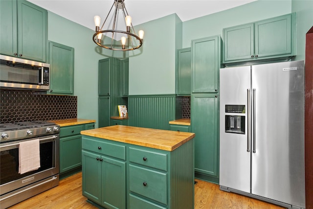 658 20th St, Des Moines, IA 50314 - kitchen with stainless steel appliances, green cabinets, wood counters, a chandelier, and wainscoting