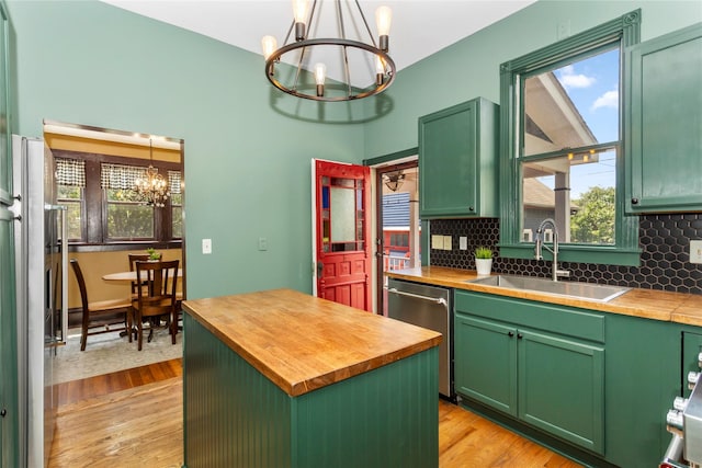 658 20th St, Des Moines, IA 50314 - kitchen featuring a chandelier, butcher block counters, green cabinets, stainless steel dishwasher, and light wood-style floors