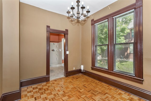 658 20th St, Des Moines, IA 50314 - unfurnished room with a chandelier and baseboards