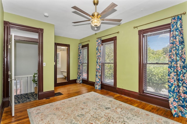 658 20th St, Des Moines, IA 50314 - bedroom with wood finished floors, multiple windows, and ensuite bathroom