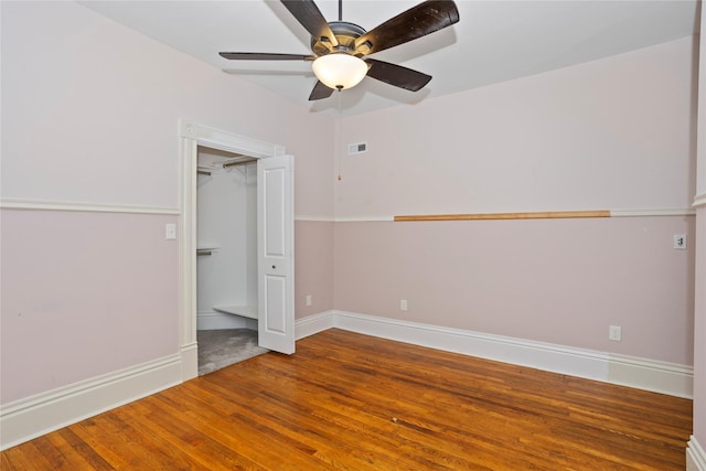 658 20th St, Des Moines, IA 50314 - unfurnished bedroom with wood finished floors, a ceiling fan, and a spacious closet