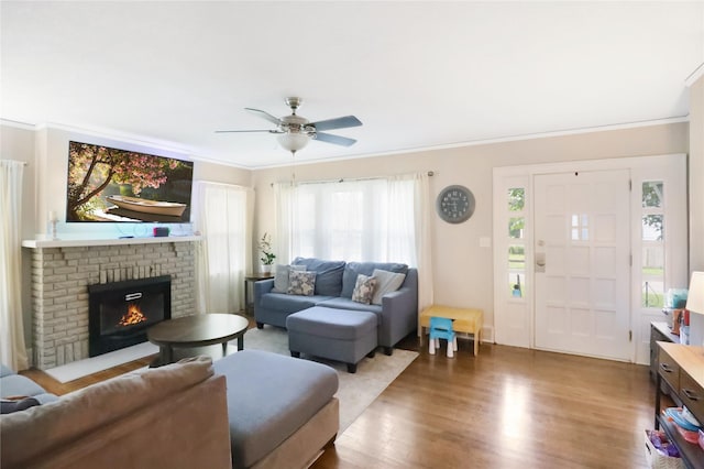 618 Arthur Ave, Des Moines, IA 50313 - living room with wood finished floors, ornamental molding, a ceiling fan, and a brick fireplace