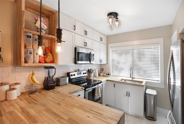 618 Arthur Ave, Des Moines, IA 50313 - kitchen featuring appliances with stainless steel finishes, white cabinets, butcher block counters, and decorative backsplash