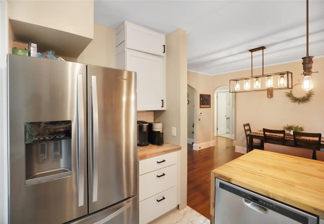 618 Arthur Ave, Des Moines, IA 50313 - kitchen with appliances with stainless steel finishes, butcher block countertops, white cabinetry, hanging light fixtures, and arched walkways