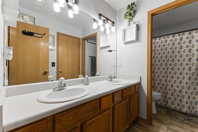 1324 College Ave, Des Moines, IA 50314 - bathroom with wood finished floors, double vanity, and a shower with shower curtain