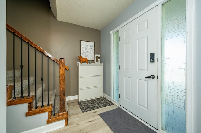550 25th St SE, Altoona, IA 50009 - entryway with stairs, wood finished floors, a textured ceiling, and plenty of natural light