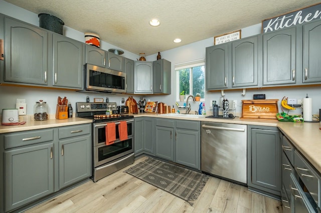 550 25th St SE, Altoona, IA 50009 - kitchen featuring stainless steel appliances, recessed lighting, green cabinetry, light wood-style floors, and a textured ceiling