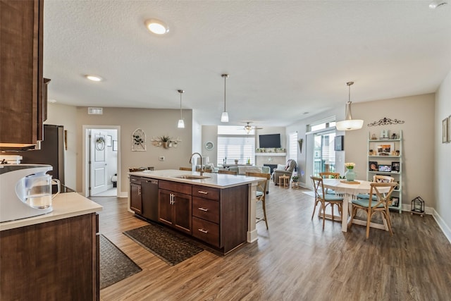 9065 Bishop Dr Unit 314, West Des Moines, IA 50266 - kitchen with dishwasher, dark brown cabinetry, dark wood-style flooring, and light countertops