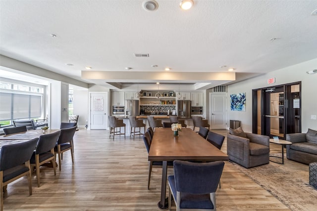 9065 Bishop Dr Unit 314, West Des Moines, IA 50266 - dining area with light wood-style floors, a textured ceiling, and recessed lighting