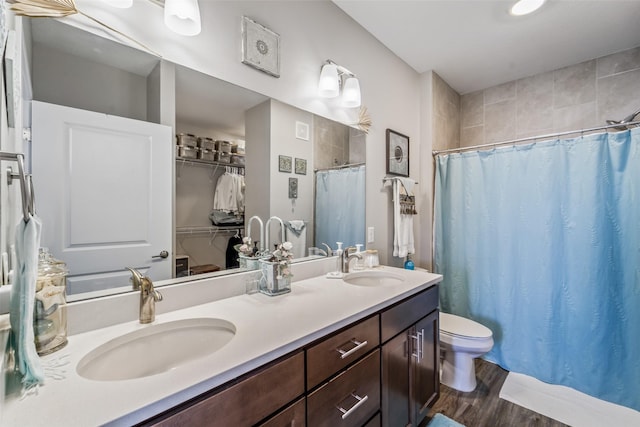 9065 Bishop Dr Unit 314, West Des Moines, IA 50266 - bathroom featuring a shower with curtain, double vanity, wood finished floors, and a spacious closet