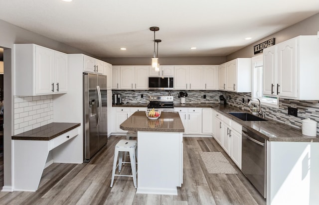 2507 135th St, Urbandale, IA 50323 - kitchen featuring stainless steel appliances, dark countertops, a kitchen island, decorative backsplash, and recessed lighting