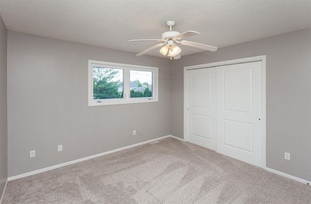 2507 135th St, Urbandale, IA 50323 - unfurnished bedroom with carpet floors, a closet, a textured ceiling, and a ceiling fan