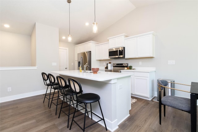 2529 SE Integra Ave, West Des Moines, IA 50265 - kitchen featuring stainless steel appliances, a center island with sink, dark wood-style flooring, white cabinets, and lofted ceiling
