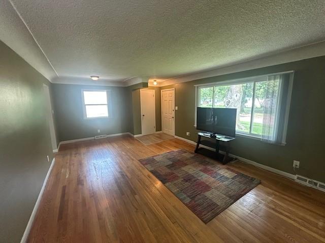 3412 Crestmoor Pl, Des Moines, IA 50310 - unfurnished living room with wood finished floors and a textured ceiling